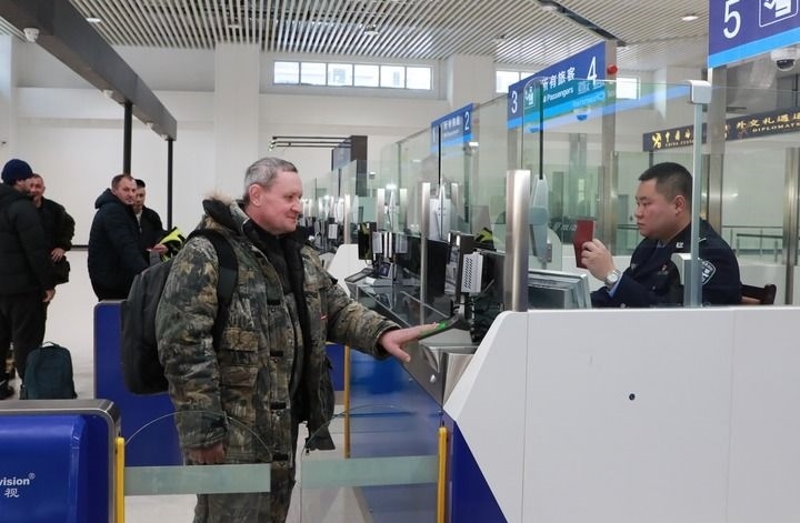 2024年12月10日，在黑河公路口岸旅檢大廳，黑河出入境邊防檢查站民警為首班次客車入境旅客辦理邊檢通關(guān)手續(xù)。當(dāng)日，中國黑河公路口岸—俄羅斯卡尼庫爾干公路口岸旅客運輸正式開通。新華社發(fā)（劉松攝）