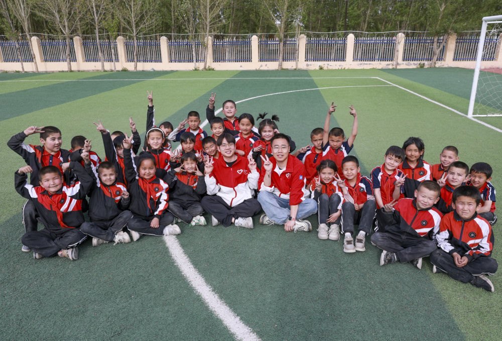 4月23日，在新疆克州阿圖什市哈拉峻鄉(xiāng)謝依特小學，支教教師王俊文（中左）、李軻凡（中右）和學生在一起。