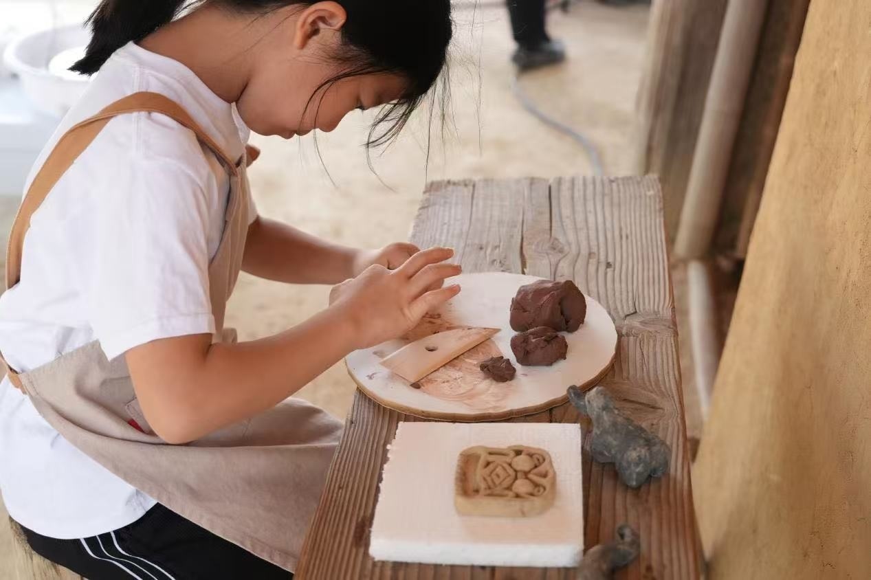 游客制作良渚特色陶藝品。良渚博物院供圖
