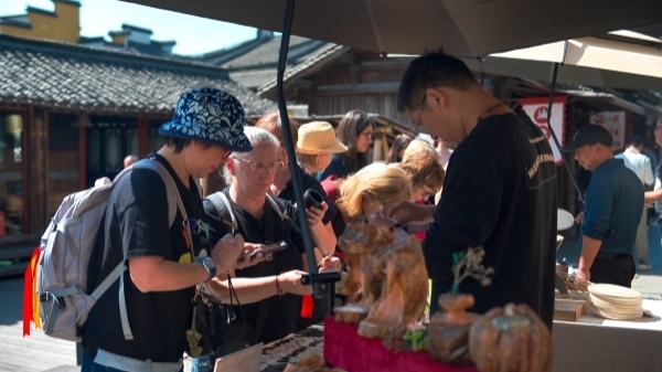 “五一”期間，游客正在烏鎮(zhèn)“水鄉(xiāng)碼頭”挑選購(gòu)買(mǎi)文創(chuàng)產(chǎn)品。受訪者供圖