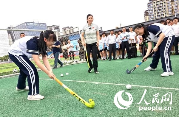陳朝霞（中）指導(dǎo)學(xué)生體驗(yàn)曲棍球。 人民網(wǎng)記者 楊磊攝