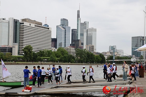 來自美國的快樂龍舟隊(duì)選手們正在登船準(zhǔn)備參賽。人民網(wǎng)記者 劉仲華攝