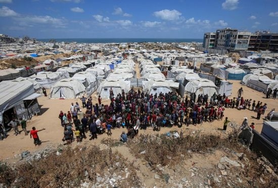 5月28日，人們在加沙城西部的沙提難民營等待領(lǐng)取救助食物。新華社發(fā)（里澤克·阿卜杜勒賈瓦德攝）