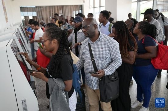 5月31日，在蒙內(nèi)鐵路內(nèi)羅畢站，乘客在自助取票機(jī)前排隊(duì)取票。新華社記者 楊光 攝