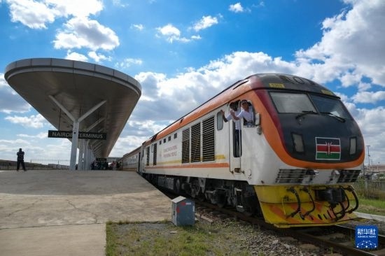 5月31日，在蒙內(nèi)鐵路內(nèi)羅畢站，機(jī)車駕駛員蔣立平（右）和博爾在即將開往蒙巴薩的E2次列車上揮手致意。新華社記者 楊光 攝