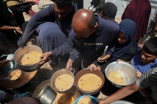 5月28日，人們在加沙城西部的沙提難民營領(lǐng)取救助食物。新華社發(fā)（里澤克·阿卜杜勒賈瓦德攝）